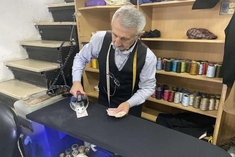 Paralarını ütüleyip cüzdanına koyuyor haberinin görseli