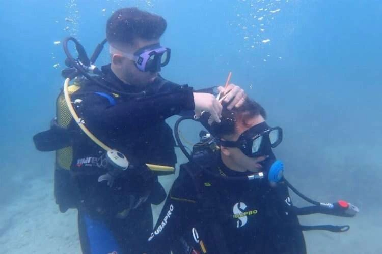 Denizin 5 metre altında saç tıraşı yaptı haberinin görseli