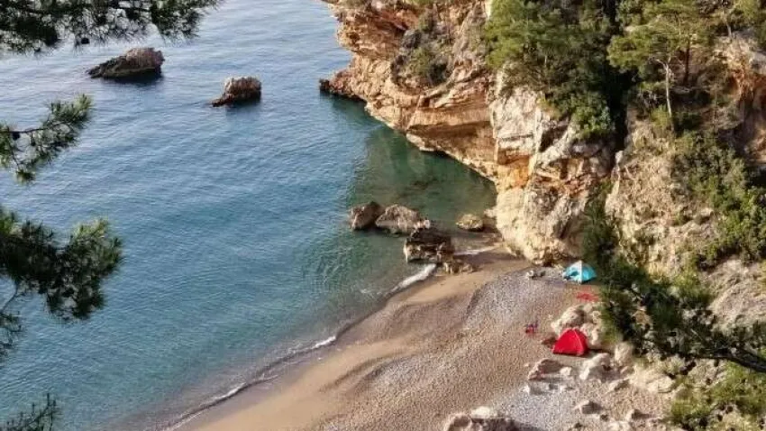 Gizli Koya giderken, hafif patika çakıl karışık bir yoldan aşağıya bir iniş gerçekleştirmek gerekiyor ancak muhteşem manzarası ve Maldivleri andıran suyu ile çekilen bütün zorluklara değiyor. Çöplük Koyu (Gizli Koy) Antalya’da yüzülecek özel yerlerden biridir. Suyun soğukluğu Antalya genelinde ki denizlere göre biraz daha serindir, berraktır ve mavinin bir çok tonunu içinde barındırmaktadır. Antalya Beldibi Gizli Koyu, Konyaaltı ilçesine bağlıdır. Kemer ilçesine de yakın olan koy Beldibi beldesinde yer almaktadır. Halk arasında gizli koy olarak bilinse de Harita Çöplük Koyu olarak geçmektedir. Koy adını gizli saklı kalmış olmasında almaktadır. Antalya -Kemer yolu üzerinde yer alan koyun girişi de adı gibi gizlidir.