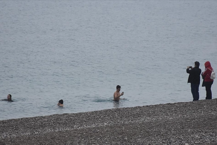 Yağmura rağmen Antalya sahilinde denize girilmeye devam ediliyor