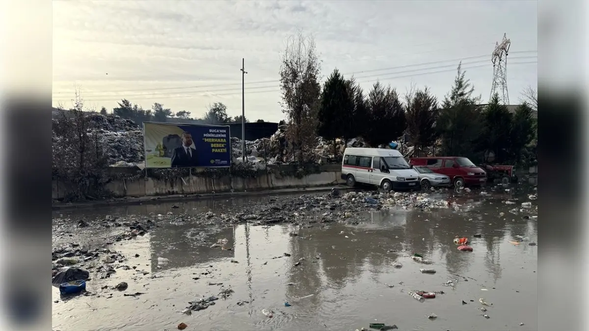 Buca’da belediye şantiyesindeki çöpler yağmurla yola taştı haberinin görseli