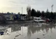 Buca’da belediye şantiyesindeki çöpler yağmurla yola taştı