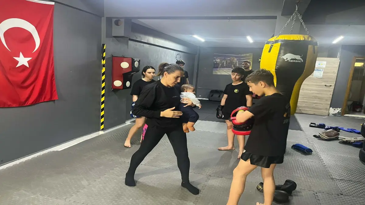 Dünya şampiyonu kick boks antrenörü, ders verdiği salonda çocuklarını büyütüyor görseli