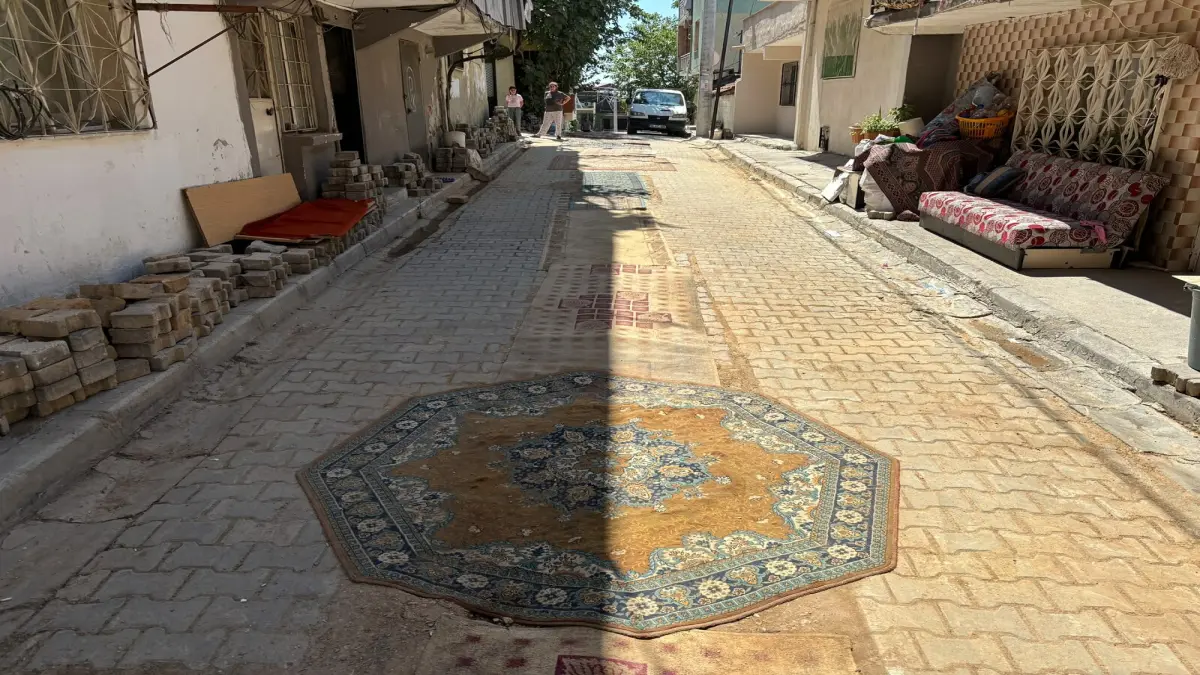 İzmir'de bir mahalle tozdan korunmak için yollara halı serdi görseli