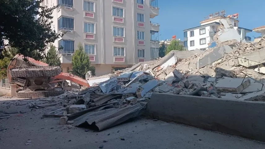 Ağır hasarlı bina yıkım esnasında kepçenin üzerine çöktü haberinin görseli